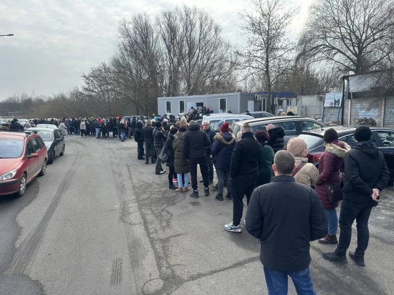 Kolejka osób stojących przed budynkiem TOZ