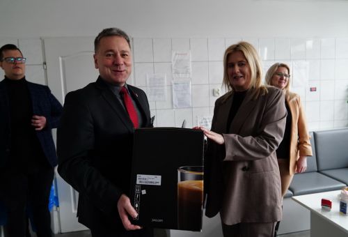 Prezydent Konina Piotr Korytkowski wręcza ekspres do kawy dyrektor stacji krwiodawstwa  Małgorzacie Tarnowskiej