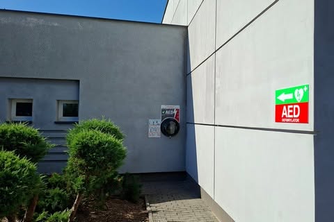 zdjęcie przedstawia defibrylator AED zawieszony na ścianie